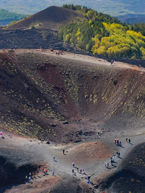Hikers exploring the rim of Mount Etna Crater in Sicily, Italy.