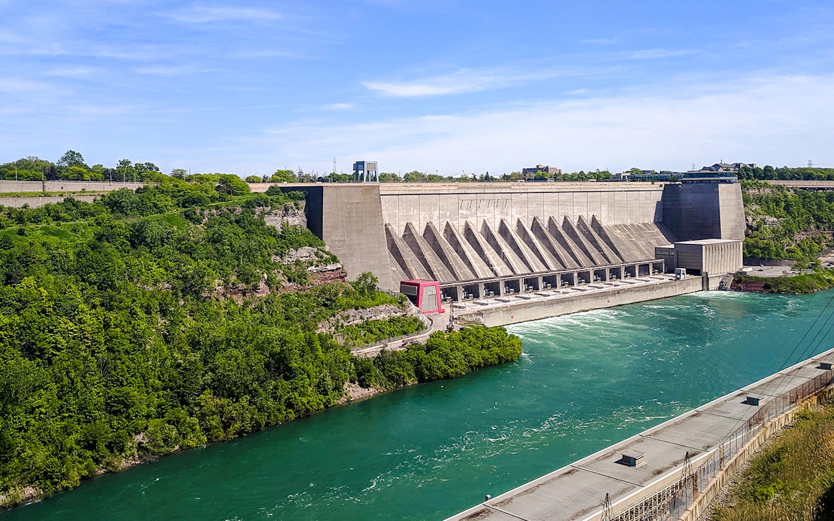 Robert Moses Power Station with flowing river, surrounded by greenery, Canada.