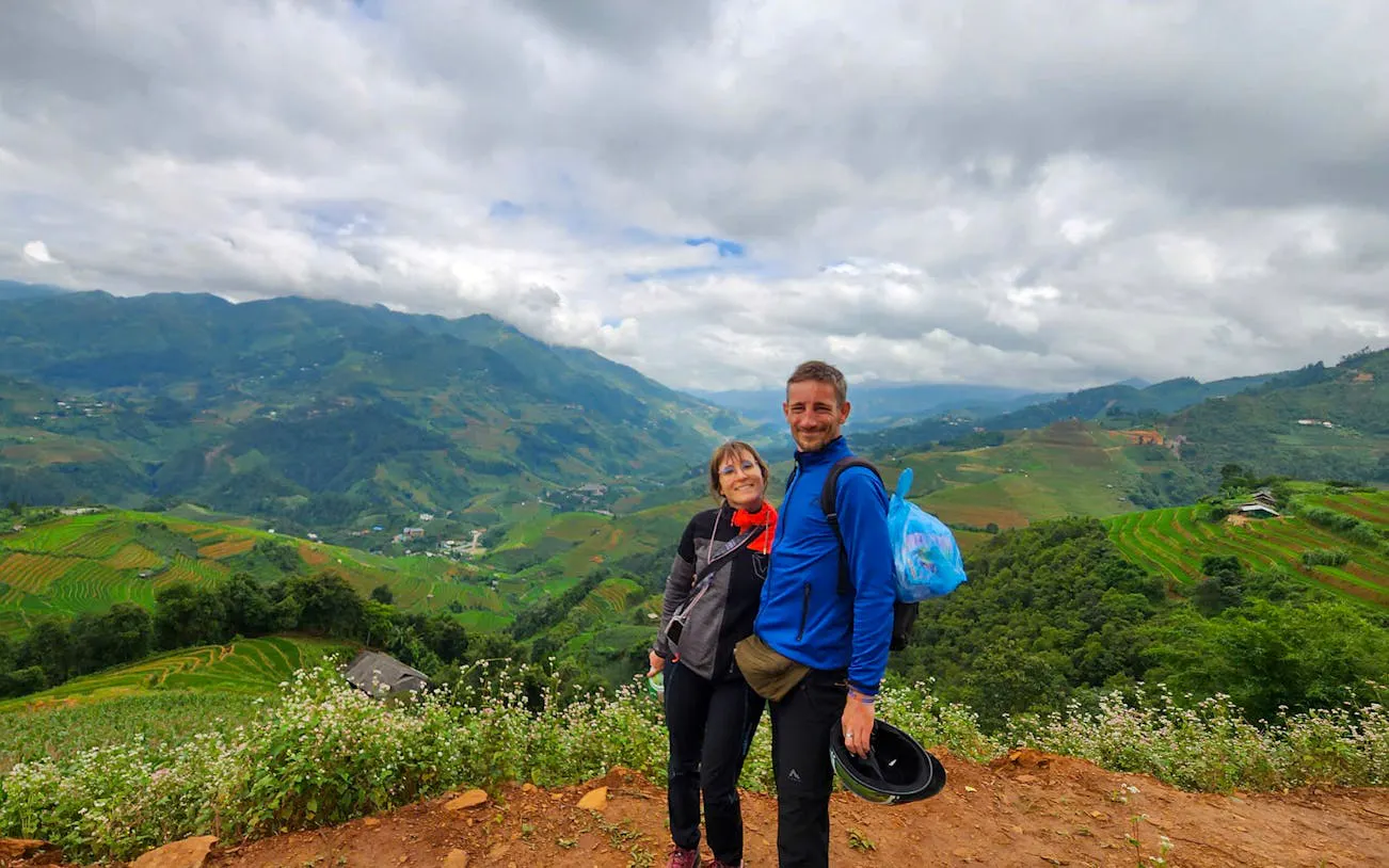 Couple enjoying view of terraced rice fields in Mu Cang Chai during trekking tour.