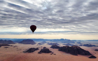 Hot air balloon over Wadi Rum desert landscape, Jordan.