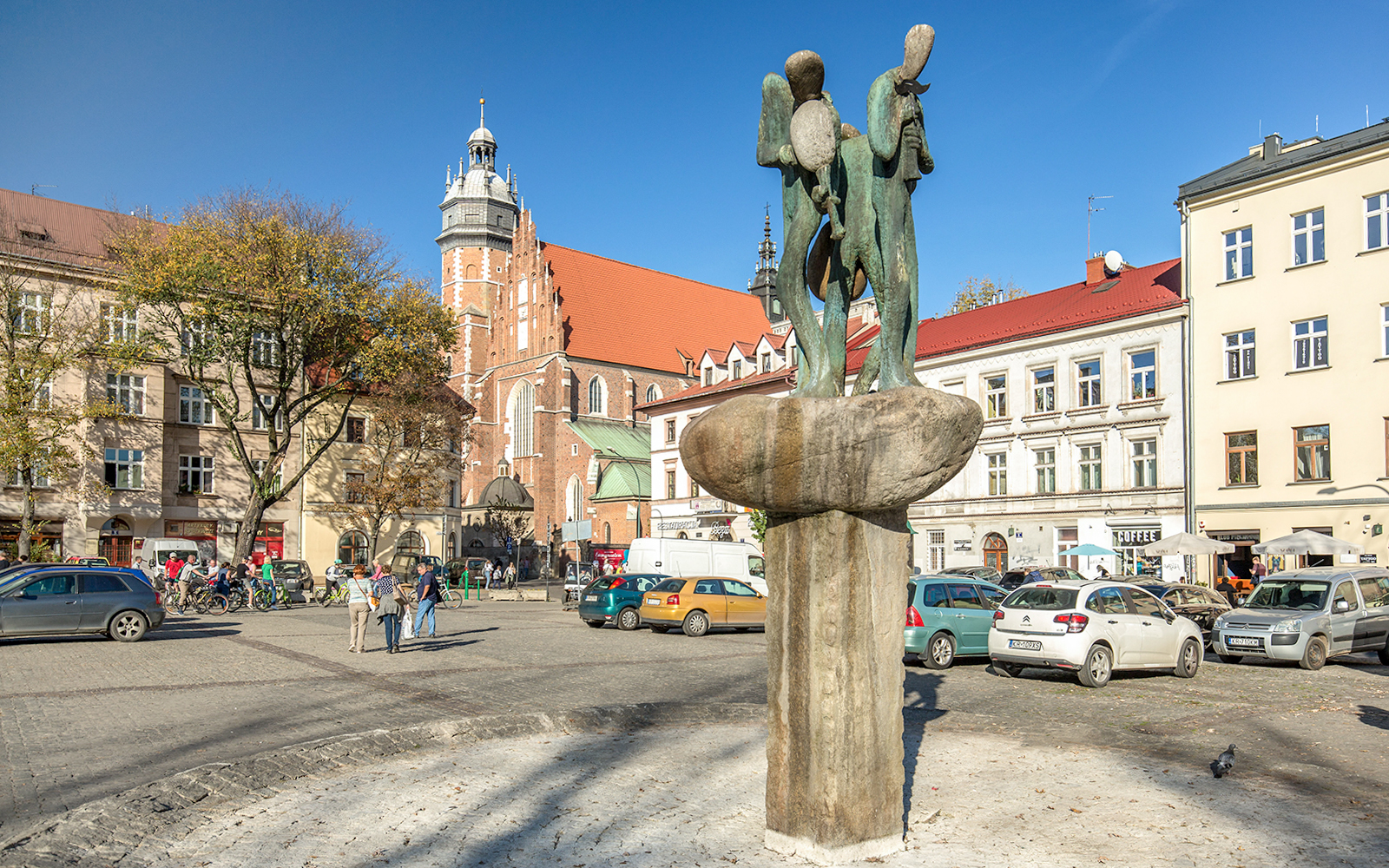 Kazimierz Plac Wolnica statue fountain in Krakow's Jewish Ghetto with historic buildings.