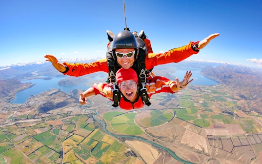 Tandem skydive over Wanaka, New Zealand, with scenic view of lakes and mountains below.
