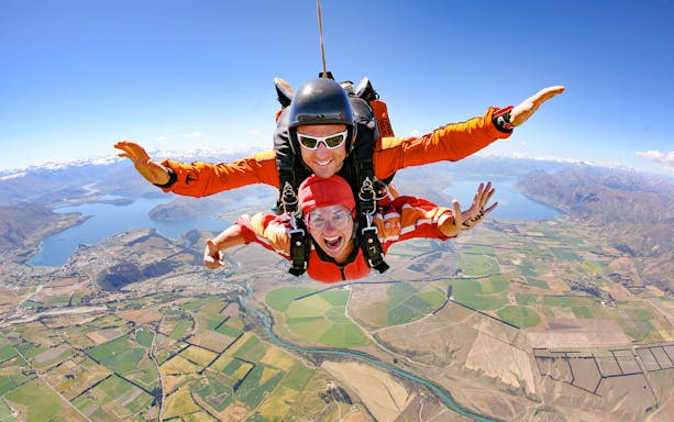 Tandem skydive over Wanaka, New Zealand, with scenic view of lakes and mountains below.