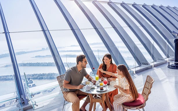 Family dining with a view of Palm Jumeirah at The View At The Palm, Dubai.