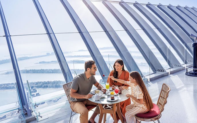 Family dining with a view of Palm Jumeirah at The View At The Palm, Dubai.