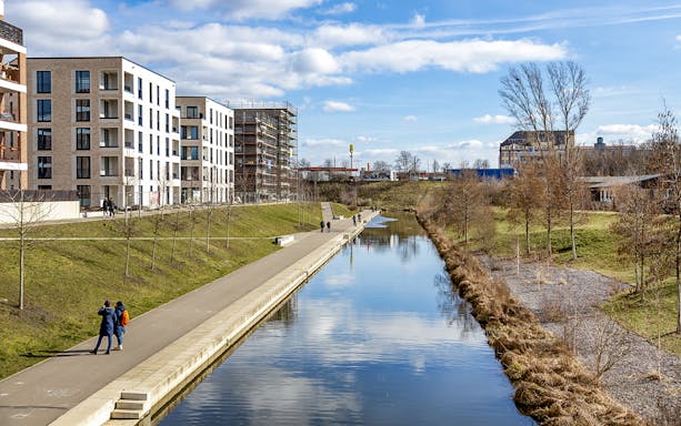 Lindenau harbor canal with modern buildings and walking path in Leipzig, Germany.