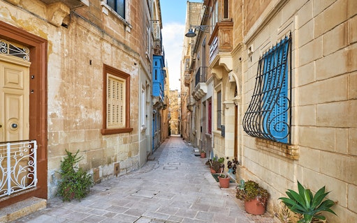 Narrow street with traditional Maltese architecture in the 3 Cities area.