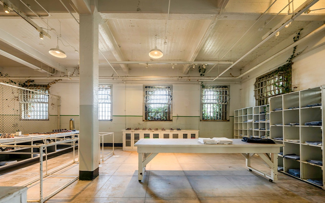 Alcatraz Island prison room with barred windows and storage shelves, San Francisco, California.