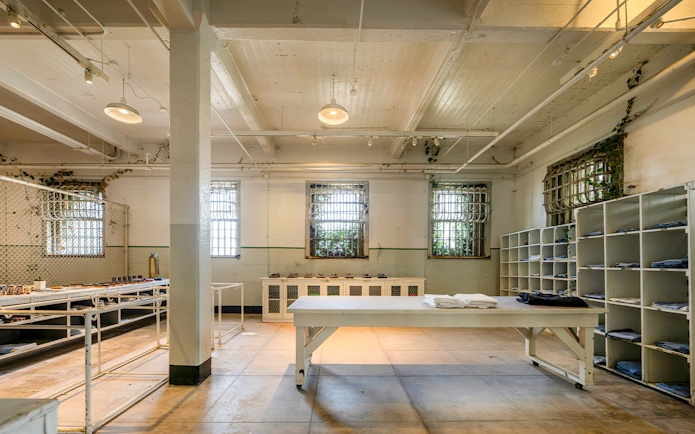 Alcatraz Island prison room with barred windows and storage shelves, San Francisco, California.