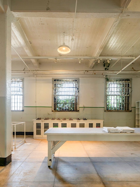 Alcatraz Island prison room with barred windows and storage shelves, San Francisco, California.