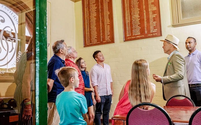 Tour group listening to a guide at Sydney Cricket Ground.