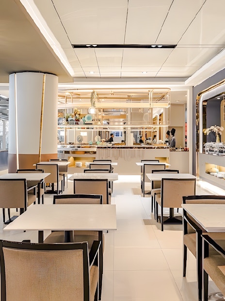 Dining area in Miracle Lounge at Bangkok Airport, featuring tables, chairs, and a buffet setup.