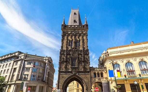 Powder Gate in Prague, a Gothic tower with ornate details, under a clear blue sky.