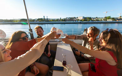 Group toasting on a sunset cruise on the Tagus River in Lisbon.