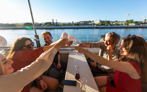Group toasting on a sunset cruise on the Tagus River in Lisbon.