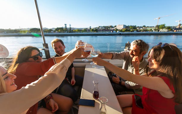Group toasting on a sunset cruise on the Tagus River in Lisbon.