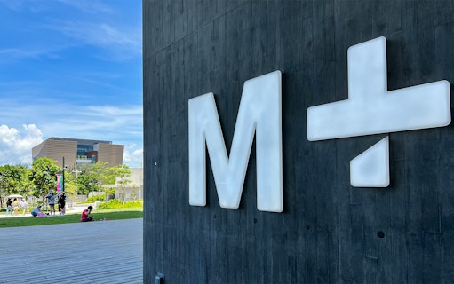 M+ Museum sign with building and park in the background, Hong Kong.