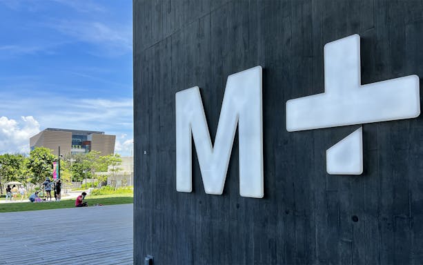 M+ Museum sign with building and park in the background, Hong Kong.