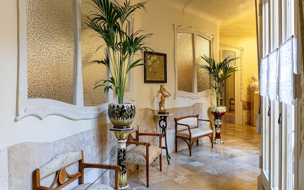 La Pedrera Casa Mila living room with ornate chairs and decorative plants.