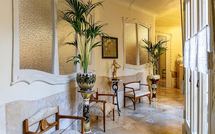 La Pedrera Casa Mila living room with ornate chairs and decorative plants.