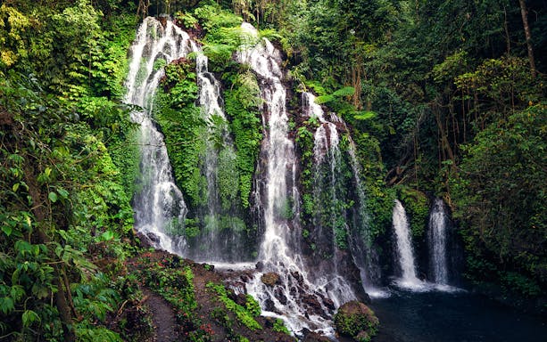 Banyumala Twin Waterfall cascading over lush greenery in Bali, Indonesia.