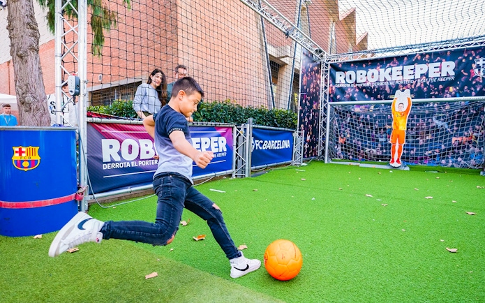 Child playing soccer at the Robokeeper exhibit, Spotify Camp Nou Barça Museum.