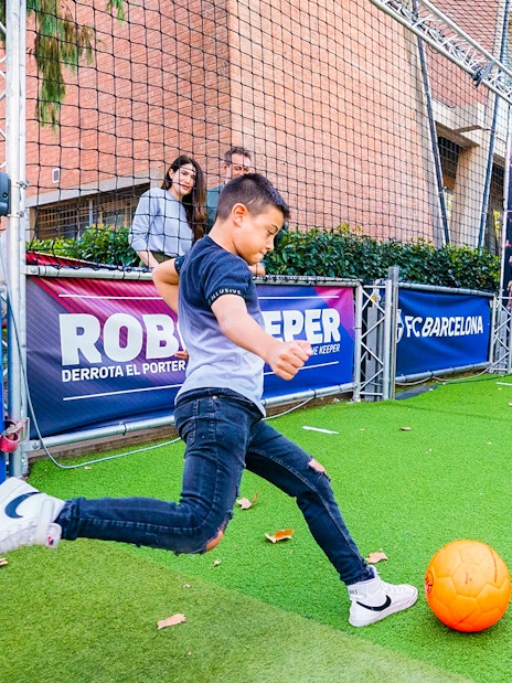 Child playing soccer at the Robokeeper exhibit, Spotify Camp Nou Barça Museum.