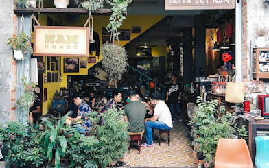 Hidden cafe in Da Nang with people enjoying drinks and conversation, part of the Sunset Hidden Cafes Tour.