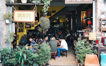 Hidden cafe in Da Nang with people enjoying drinks and conversation, part of the Sunset Hidden Cafes Tour.
