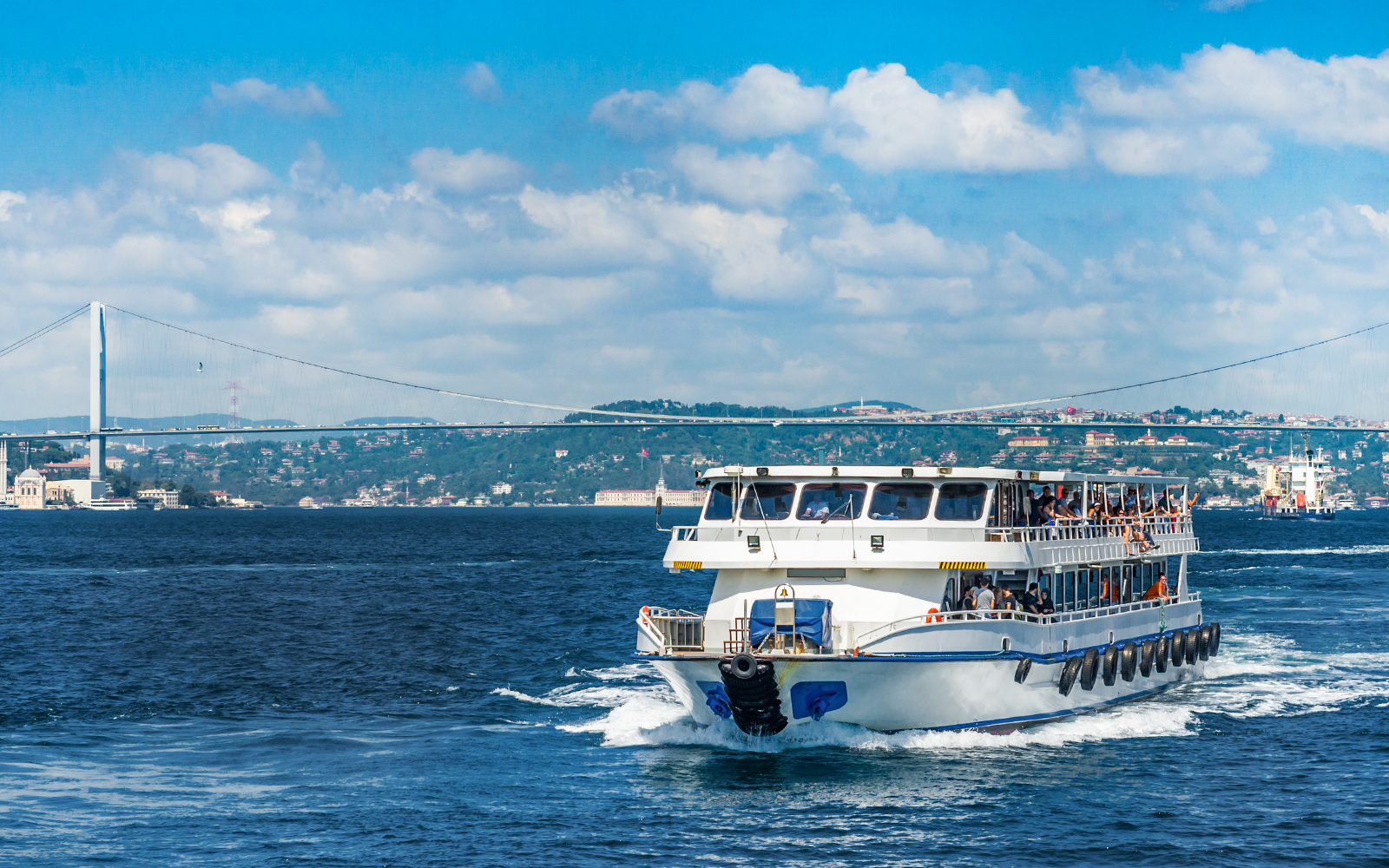 Cruise ship on Bosphorus Strait with bridge in Istanbul, Turkey.