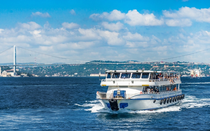 Cruise ship on Bosphorus Strait with bridge in Istanbul, Turkey.