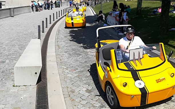 Yellow GoCars driving on a cobblestone street during a self-guided tour in Porto.