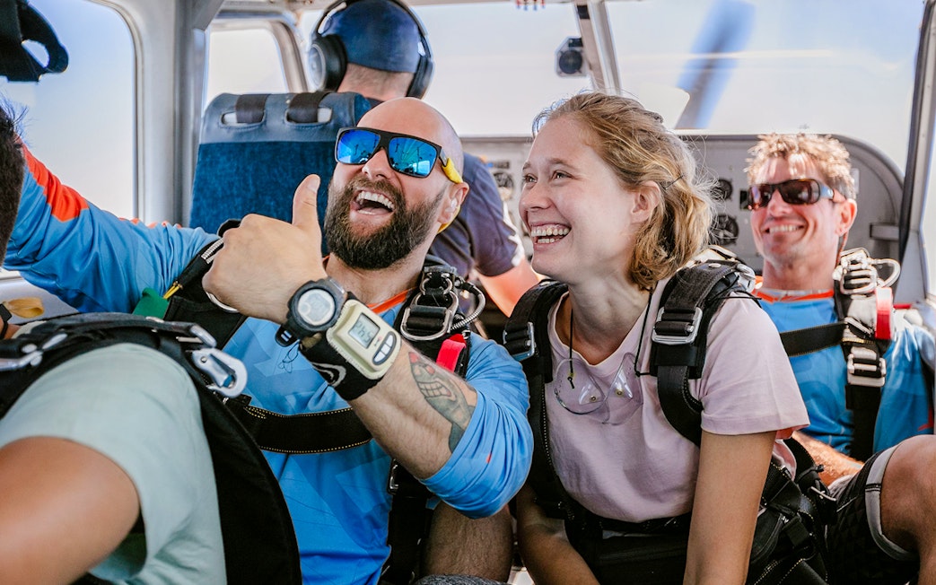 Skydivers smiling inside plane before tandem jump, Rottnest Island.
