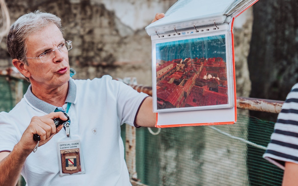 Guide showing a map of Herculaneum during a private tour.