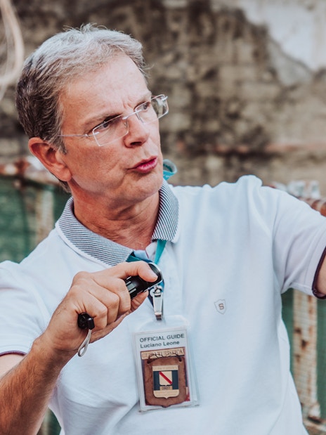 Guide showing a map of Herculaneum during a private tour.