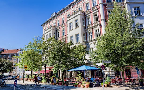 Berlin street scene with outdoor cafes and historic buildings on a guided bike tour route.