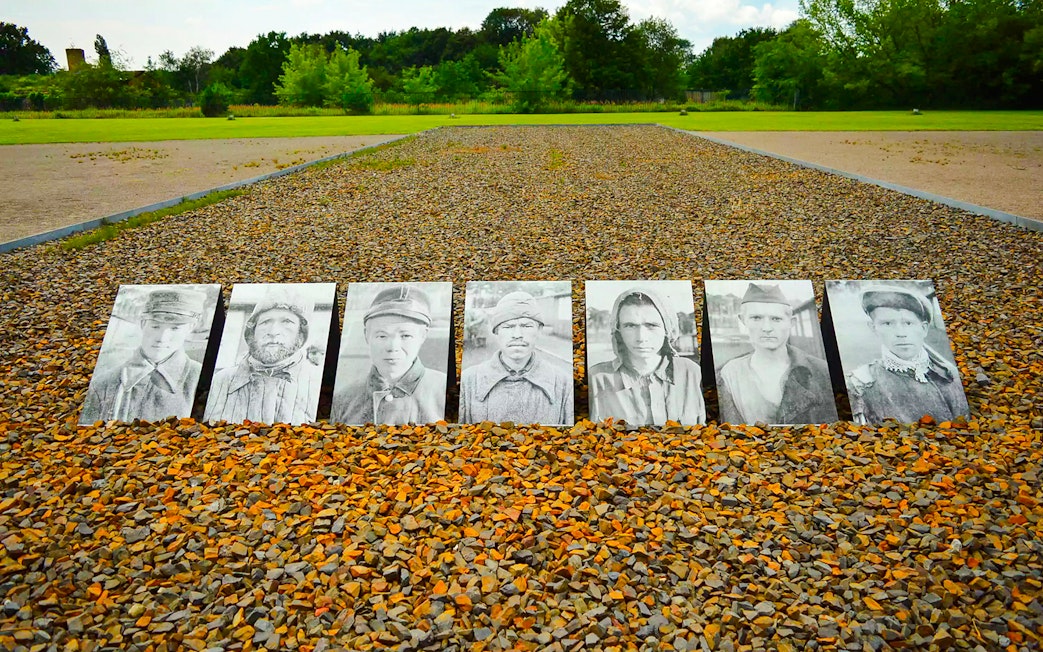 Portraits of prisoners displayed on gravel at Sachsenhausen Concentration Camp Memorial.