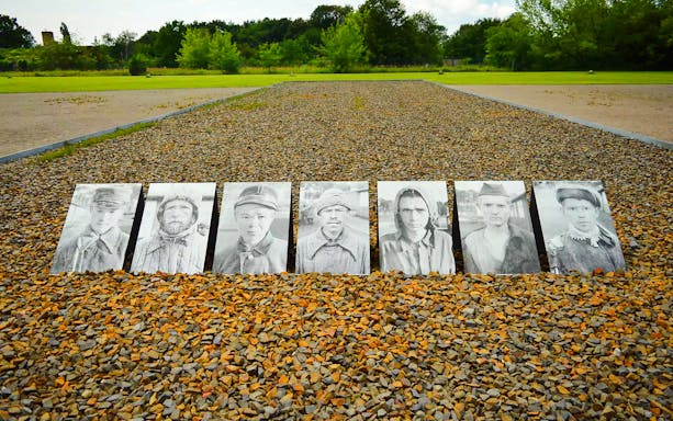 Portraits of prisoners displayed on gravel at Sachsenhausen Concentration Camp Memorial.