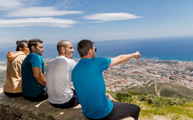 Hikers enjoying the view from Benalmádena mountain summit, overlooking the coastline.