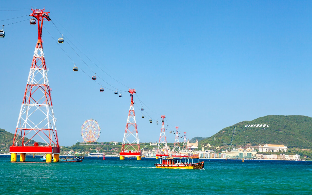 Cable car over water to Vinpearl Island, Nha Trang with ferris wheel in background.