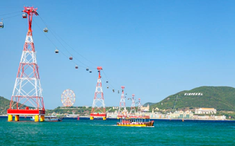Cable car over water to Vinpearl Island, Nha Trang with ferris wheel in background.