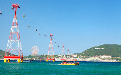 Cable car over water to Vinpearl Island, Nha Trang with ferris wheel in background.