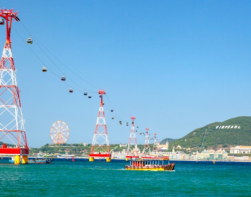 Cable car over water to Vinpearl Island, Nha Trang with ferris wheel in background.