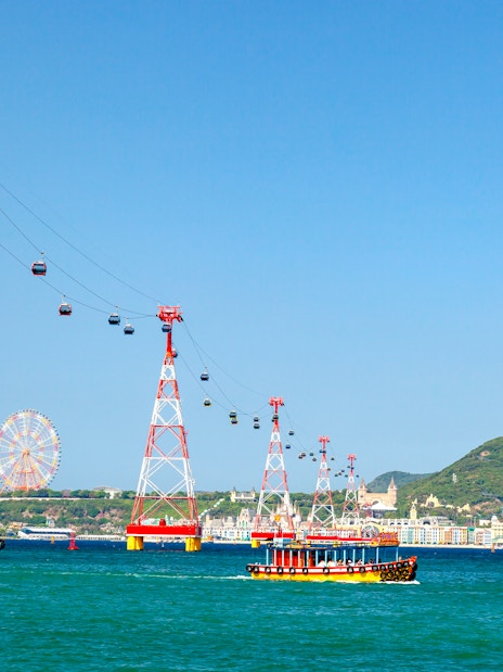 Cable car over water to Vinpearl Island, Nha Trang with ferris wheel in background.