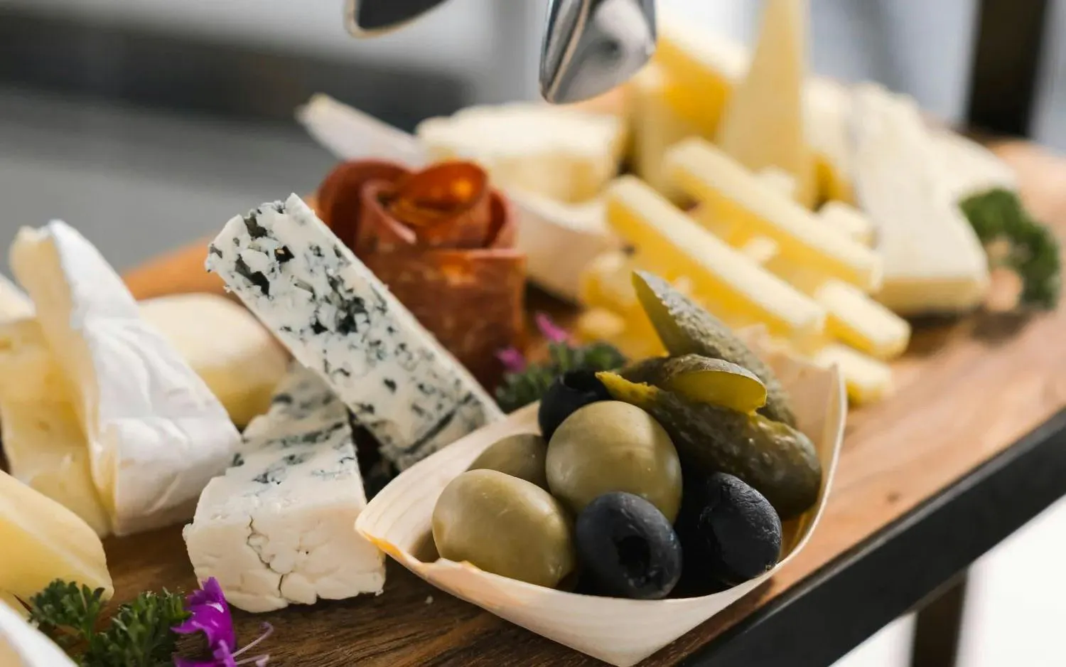 Cheese platter with olives and pickles on Milford Sound tour buffet.