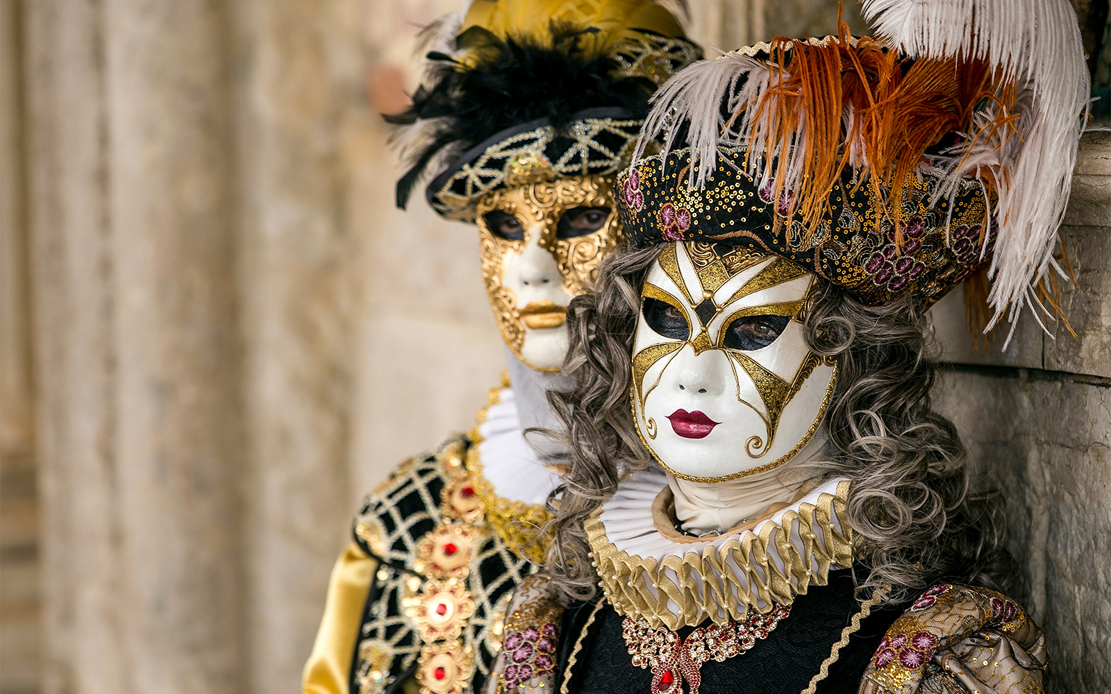 People wearing Venice Carnival masks at a lively gambling table in Venice, Italy.