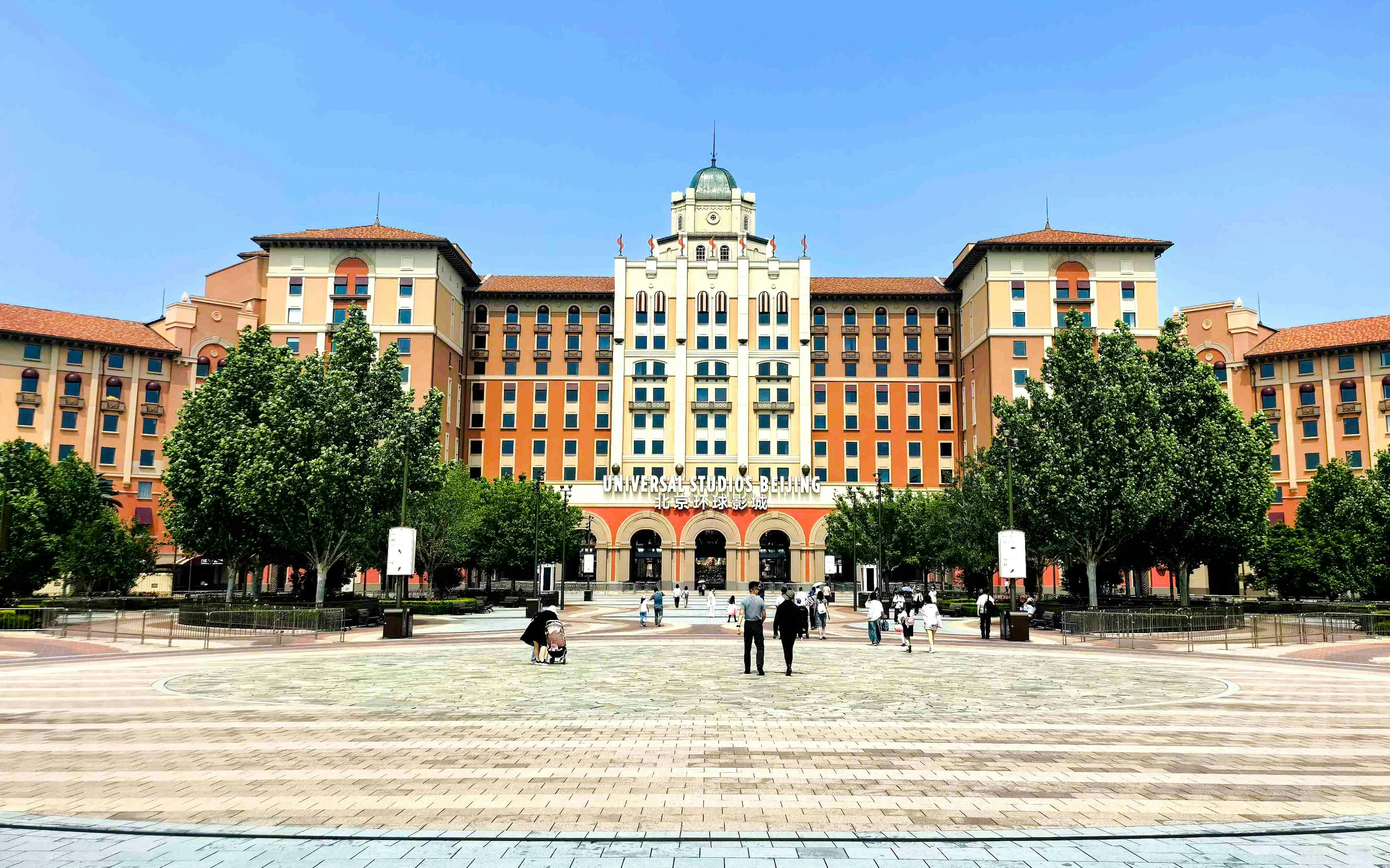 Entrance to Universal Studios Beijing with people walking in the plaza, China.