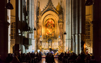 Classical concert at Minoritenkirche with audience seated in the illuminated church interior.