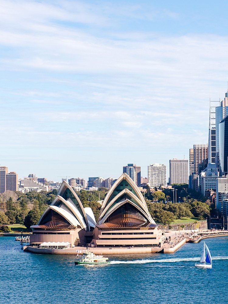 Sydney Opera House with ferry and sailboat on Sydney Harbour.