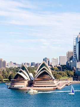 Sydney Opera House with ferry and sailboat on Sydney Harbour.